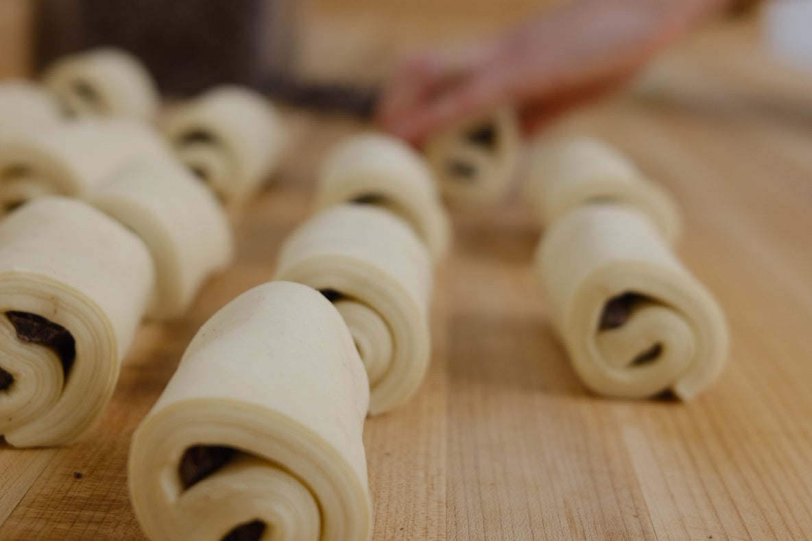 Laminated dough rolled by hand on the bakery bench